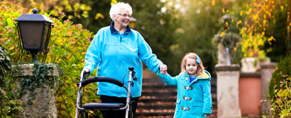 Elderly Woman Walking Hand-In-Hand With Small Child Outdoors